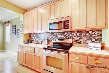 64698827 - light wood cabinets with multicolored backsplash and modern stainless steel appliances. northwest, usa