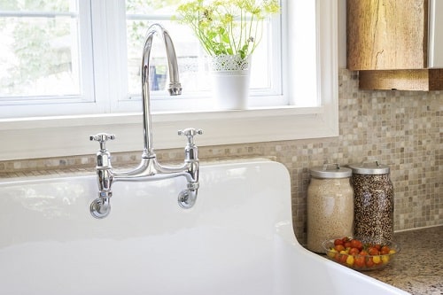 A Sink With Tile Backsplash in the Background